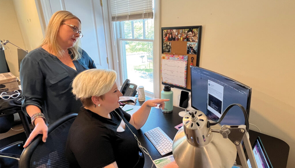 Digital Marketing Director Kimberly Kulp and Digital Marketing Specialist Teddie Raymond looking at a project on the computer