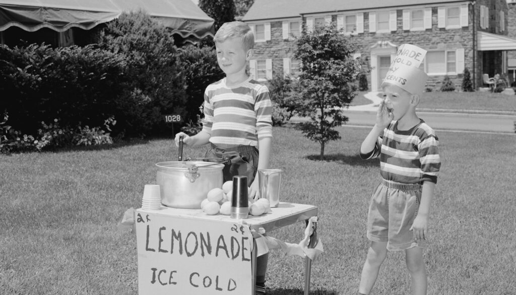 1950s black and white photo of two boys running a lemonade stand