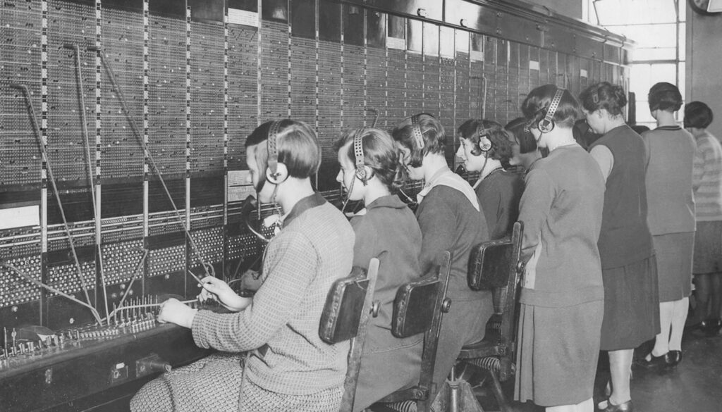 1950s black and white photo of operators at a call board