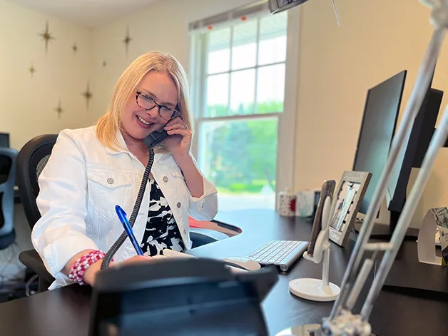 FatRabbit Creative's Director of Digital Marketing, Kimberly Kulp, smiling on the phone with a client