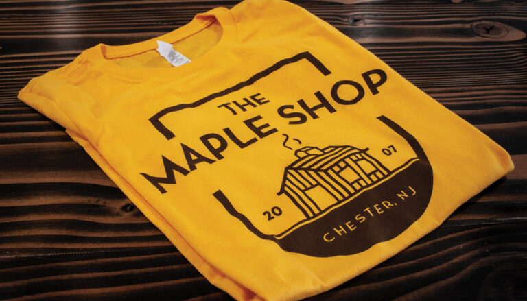 The Maple Shop logo on a yellow shirt